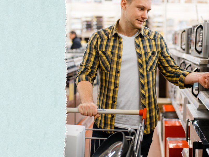 A shopper choosing a microwave in an electronics store